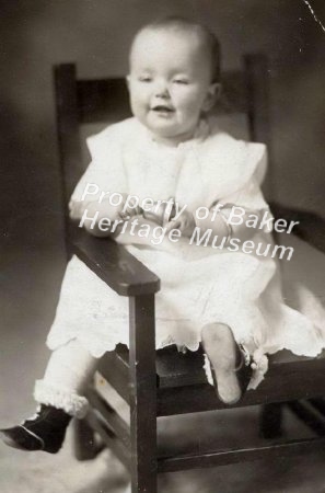 Child on chair holding a bell