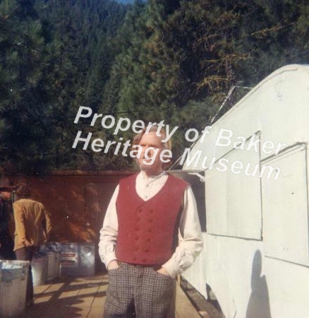 Man in Red Vest standing by tr